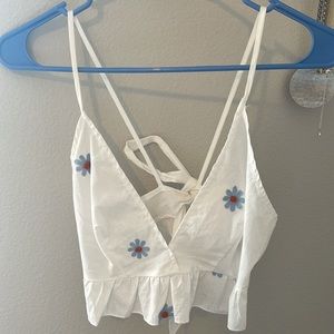 White tank top with embroidered blue flowers, adjustable tie back